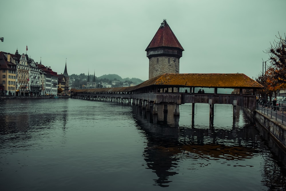 a clock tower on a bridge over a body of water