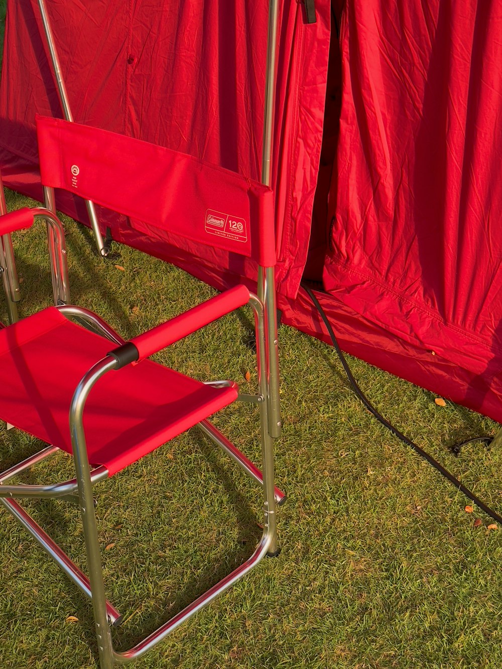 a couple of red chairs sitting on top of a lush green field