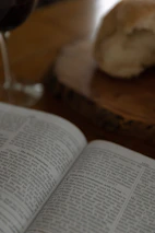Open book with notes and maps related to geogastronomy on a wooden table.