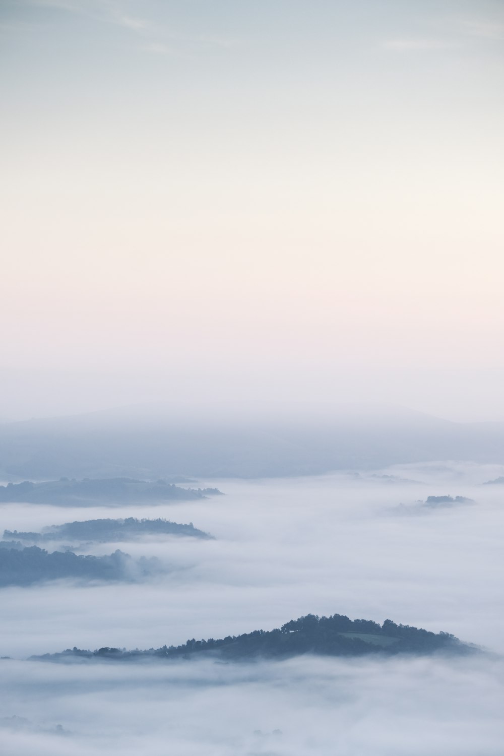 a view of a mountain covered in fog