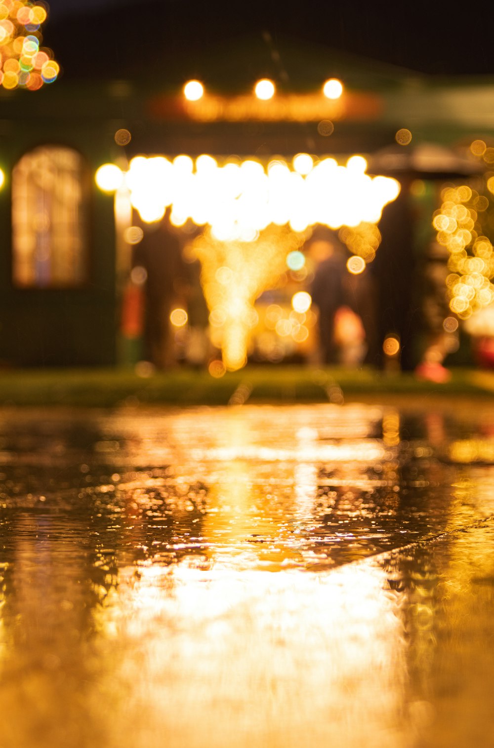 a close up of a wet surface with lights in the background