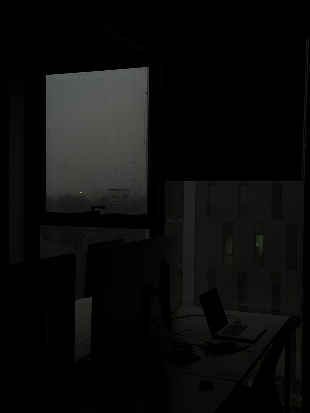 a dark room with a laptop and a monitor