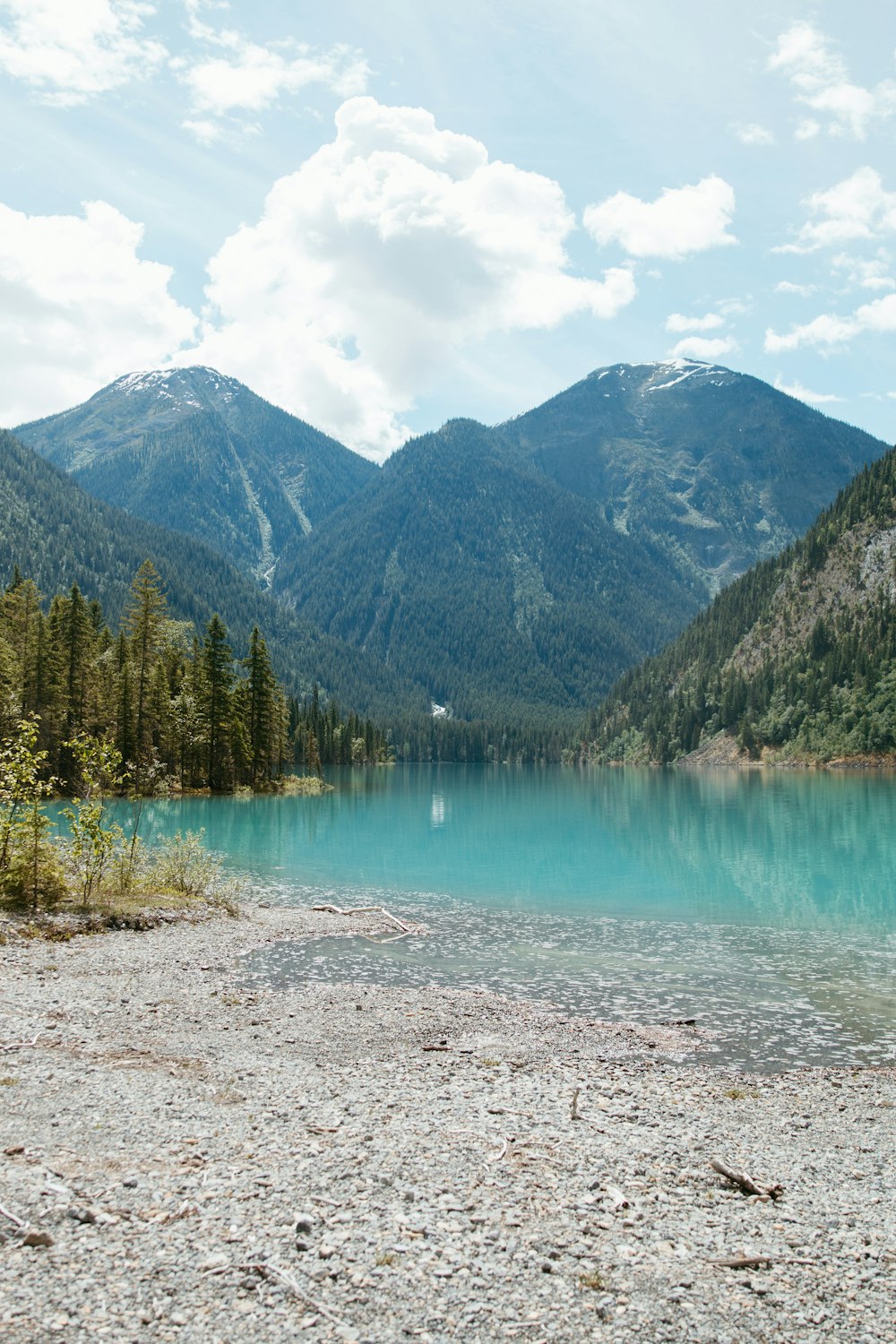 a lake surrounded by mountains in the middle of a forest