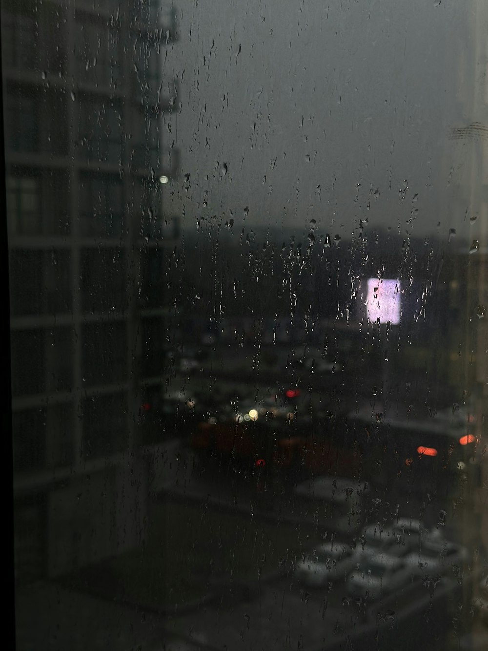 a view of a city through a rainy window