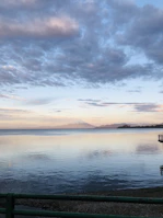 A serene mountain lake reflecting pastel skies at dawn.