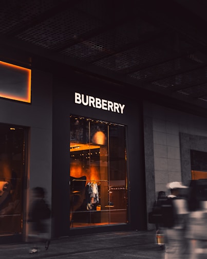 a blurry photo of people walking past a burbery store