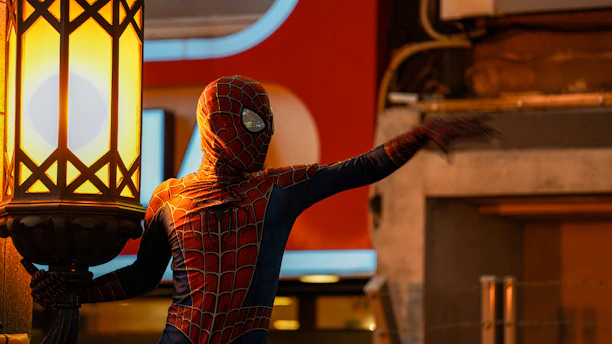 a man in a spider suit holding a lamp