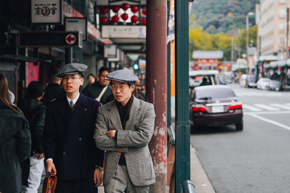 a couple of men standing next to each other on a street