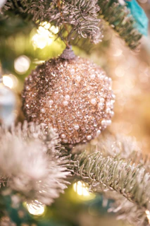 Sparkling handcrafted ornaments hanging from a rustic branch