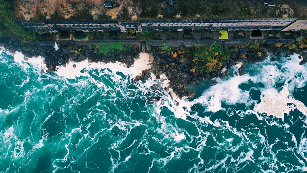 an aerial view of the ocean and a pier