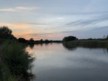 A peaceful riverside view at sunset near San José del Guaviare, highlighting natural beauty.