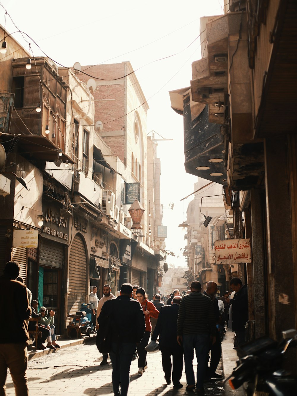 a group of people walking down a street next to tall buildings