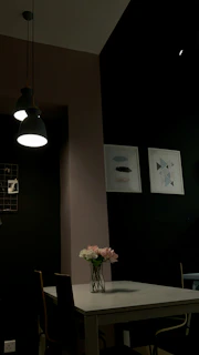 A stylish corner of a home with minimalist décor, featuring a vase of fresh flowers and warm lighting.