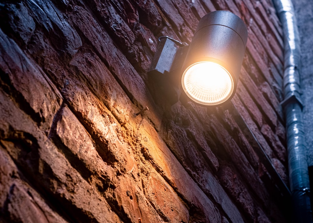 a close up of a street light on a brick wall