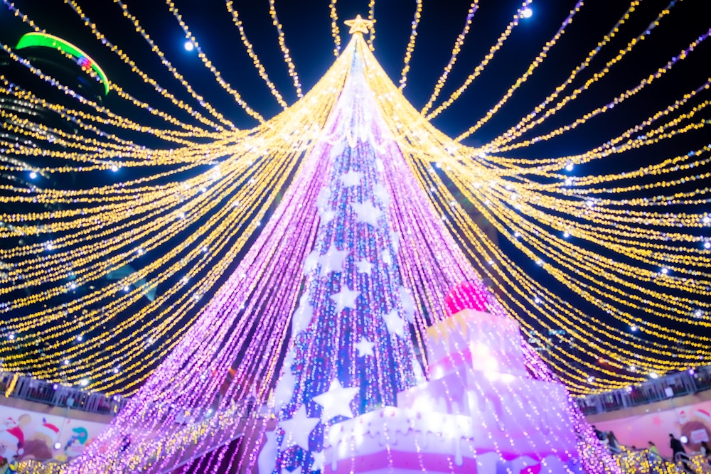 Un grande albero di Natale è illuminato con luci