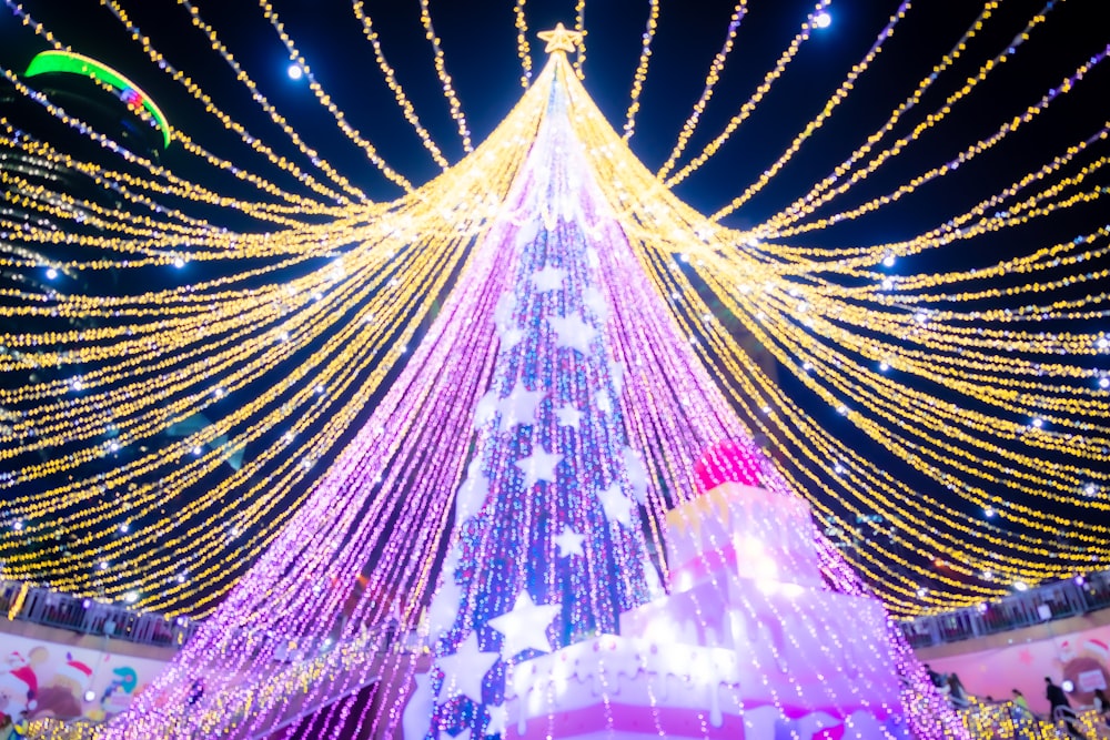 a large christmas tree is lit up with lights