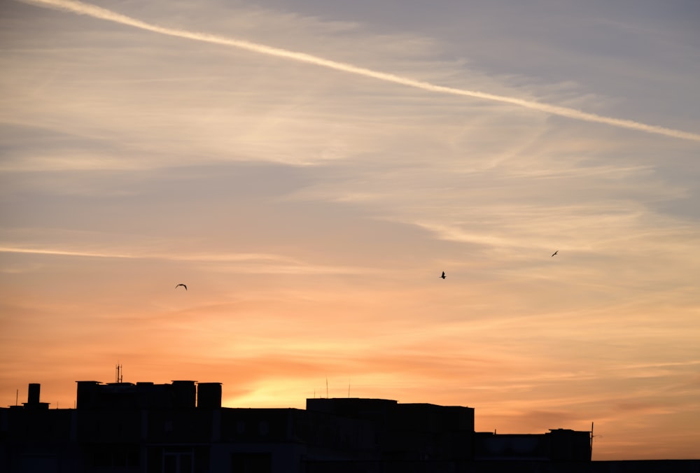 a sunset with contrails in the sky