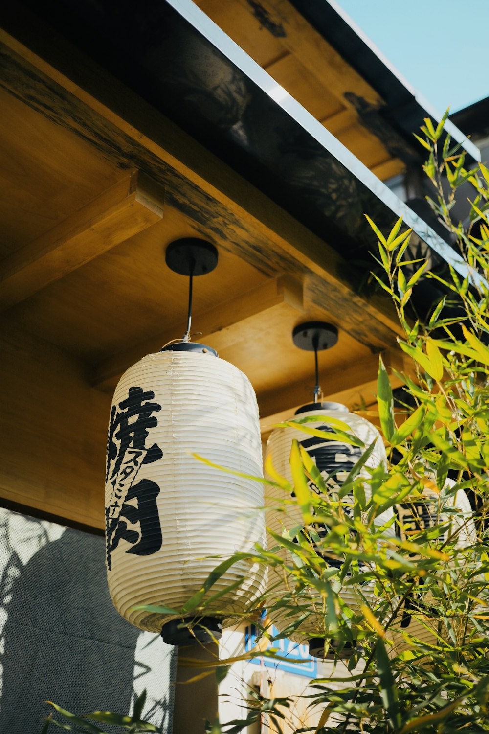 a couple of lanterns hanging from a wooden roof