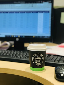 A calm desk scene with a laptop displaying financial charts and a cup of coffee nearby.