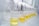 A series of glass beakers and Erlenmeyer flasks are lined up on a laboratory table, each containing a yellow liquid. Funnels are placed in the necks of the flasks and beakers, indicating a filtration or liquid processing activity. The table surface is reflective, enhancing the clarity and brightness of the glassware.