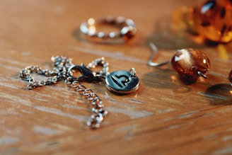 a wooden table topped with lots of different types of jewelry