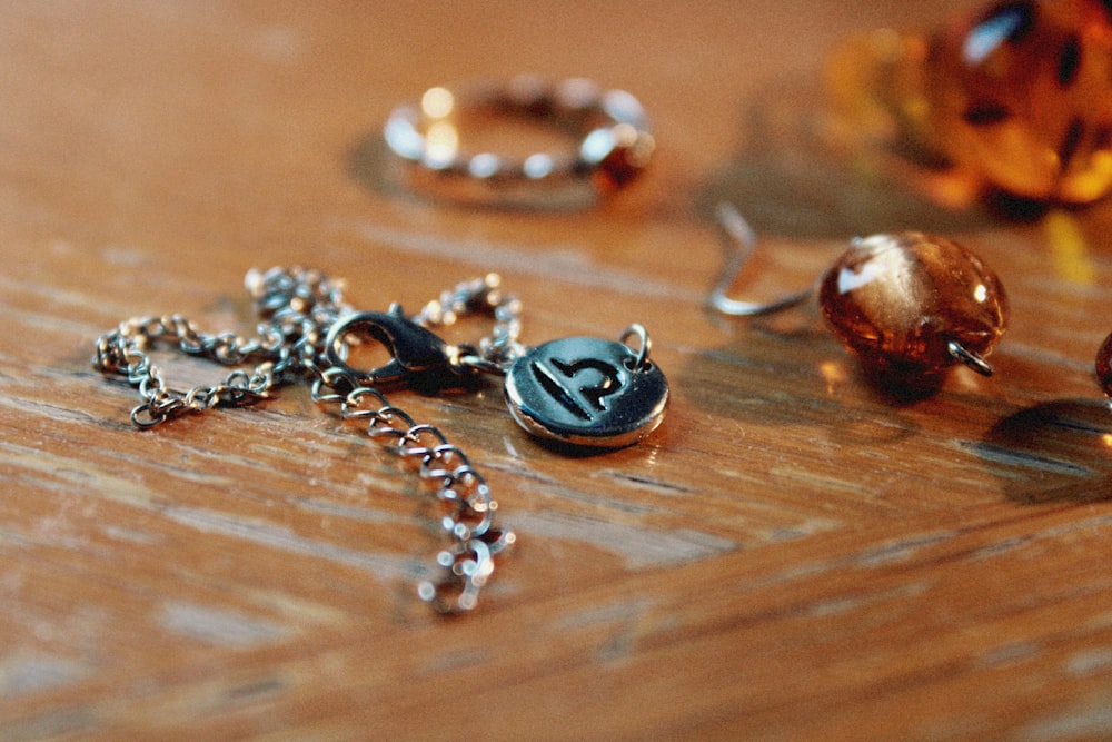 a wooden table topped with lots of different types of jewelry