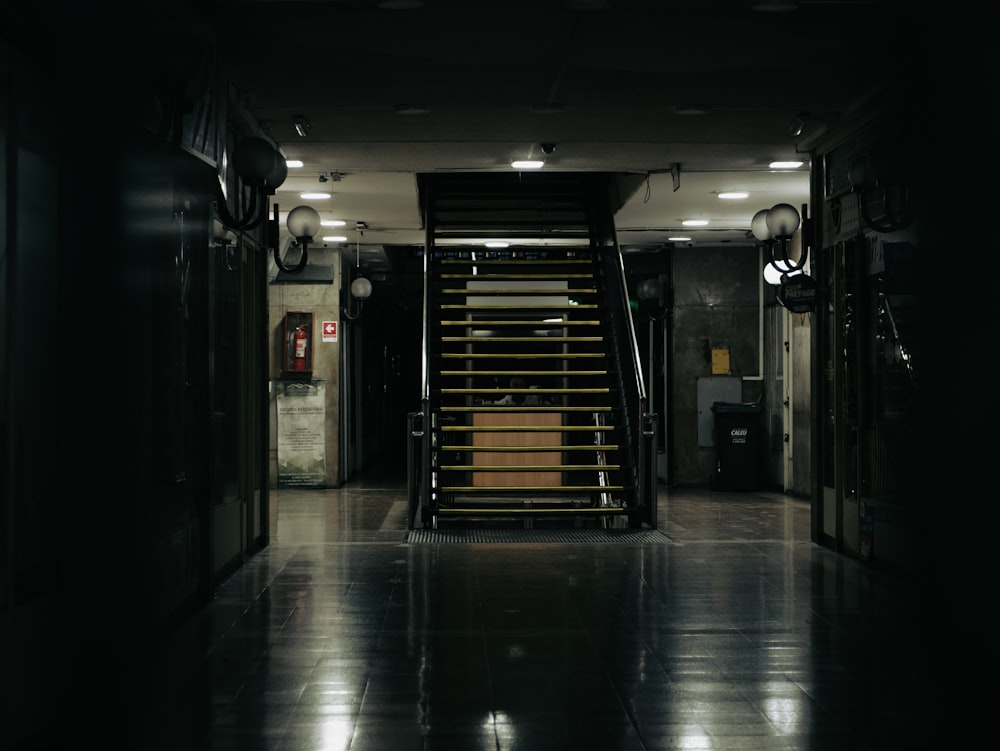 a dark hallway with stairs leading to a phone booth