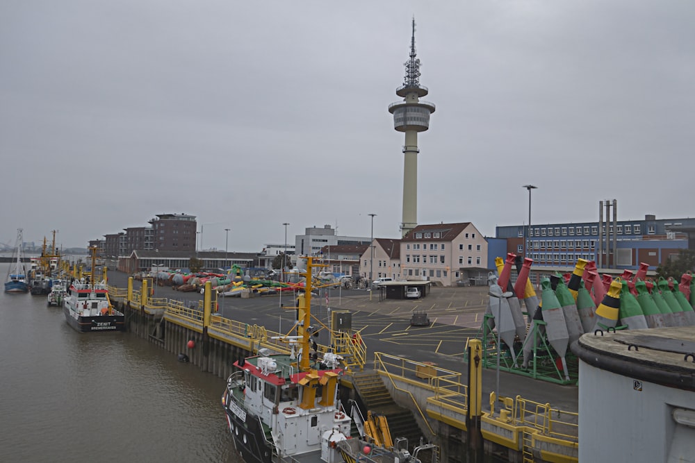um porto cheio de barcos ao lado de uma torre alta