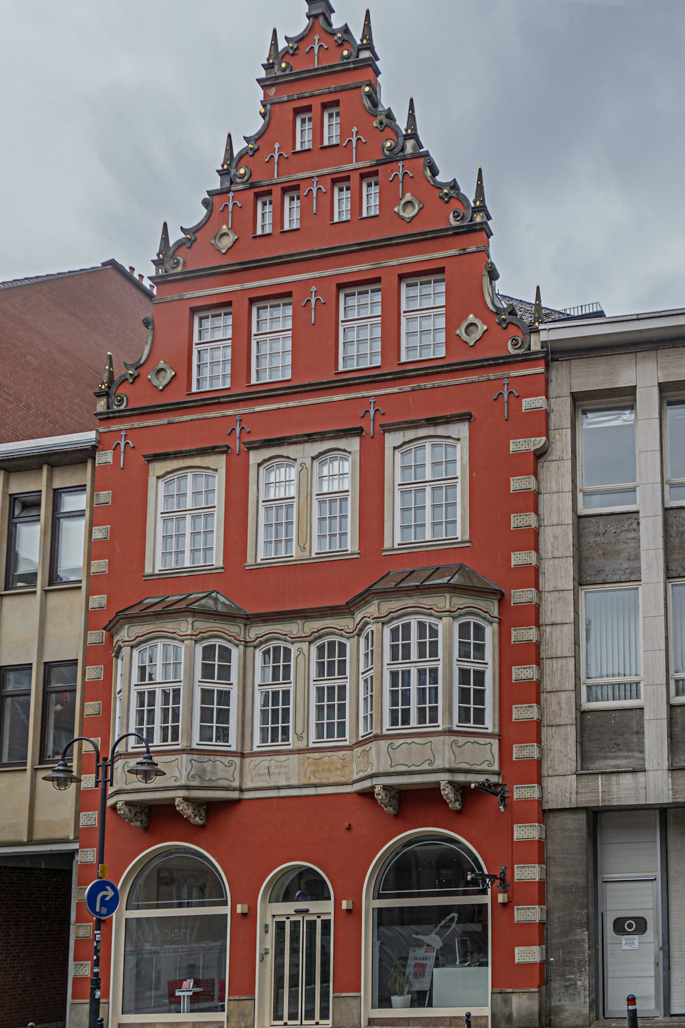 un alto edificio rojo con un reloj en la parte superior