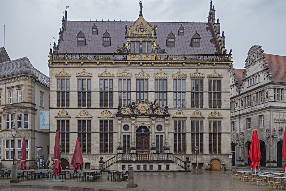 a large building with red umbrellas in front of it