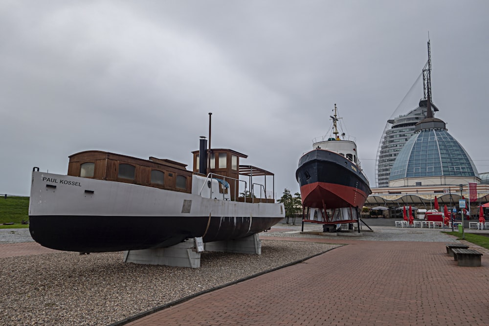 a large boat sitting on top of a gravel field