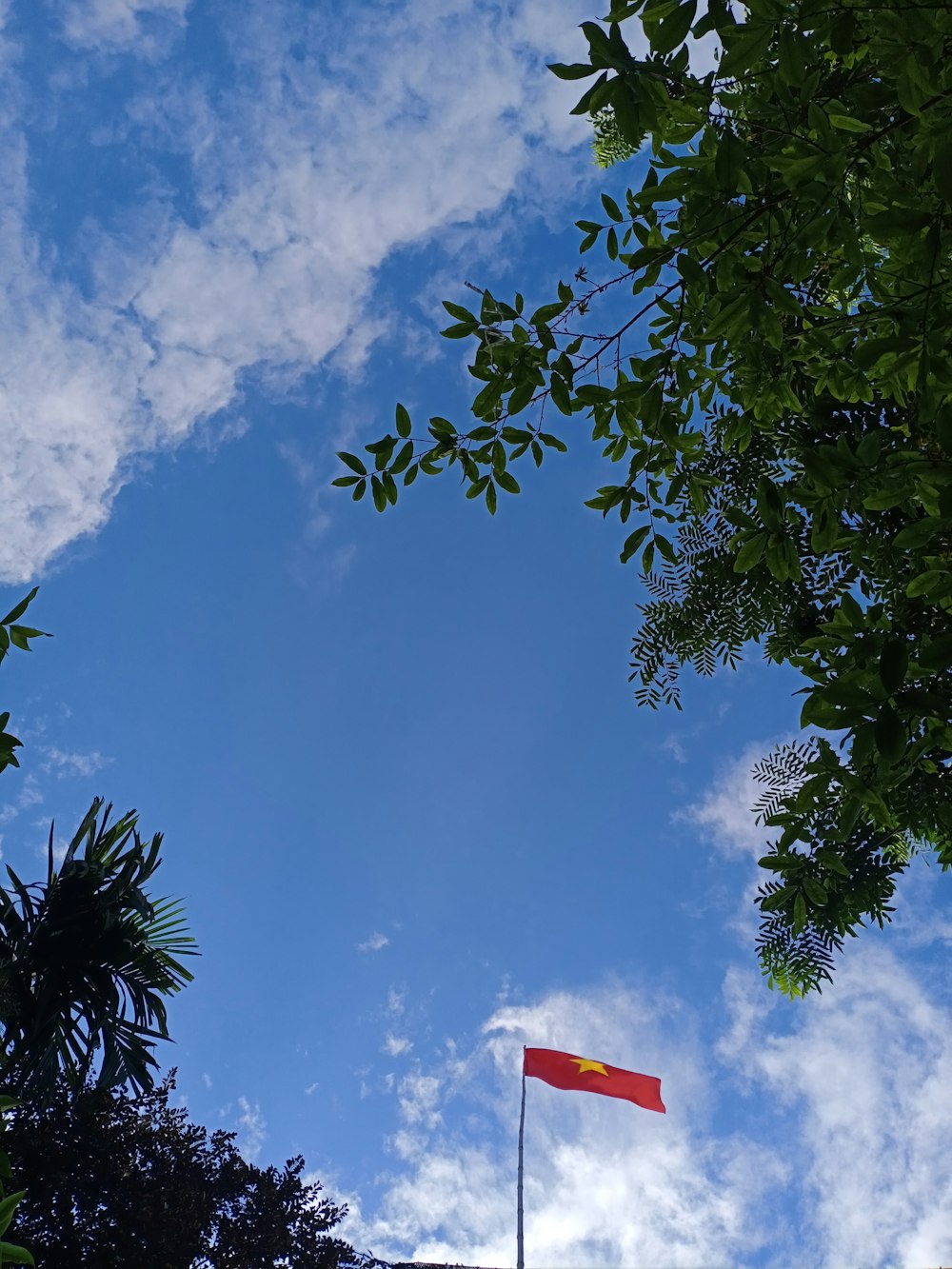 a red and yellow flag flying in the sky