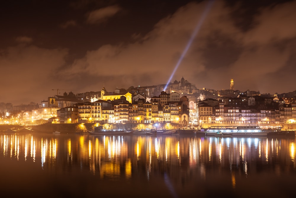 a city lit up at night with lights reflecting in the water