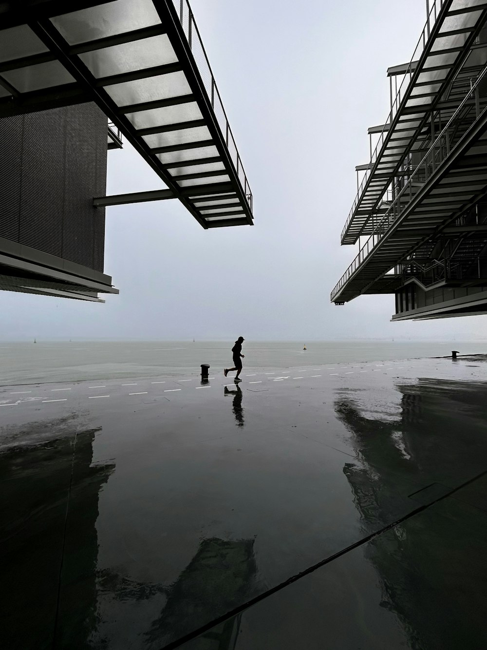 a couple of people standing on top of a wet beach