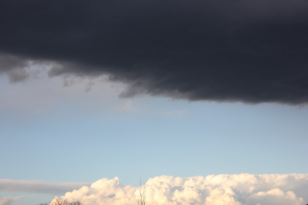 a large black cloud looms over a field