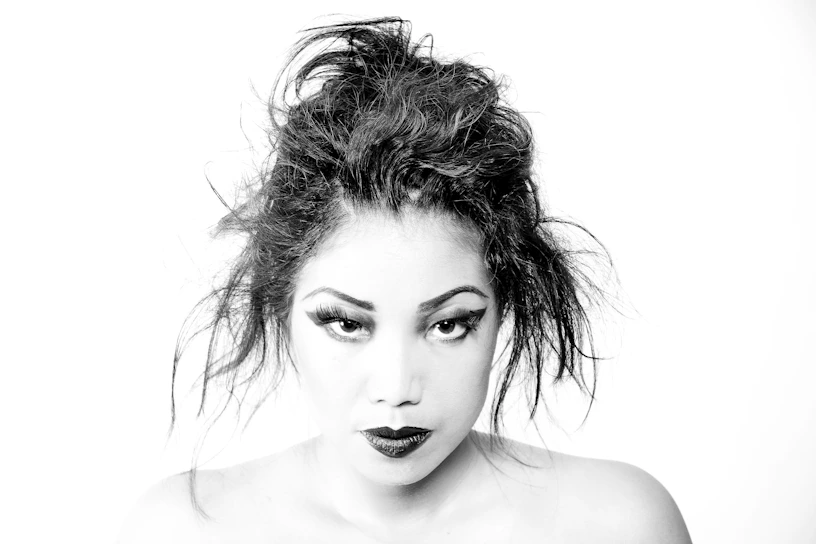 A stark black-and-white portrait of a person with bold makeup, highlighting identity through minimalism.
