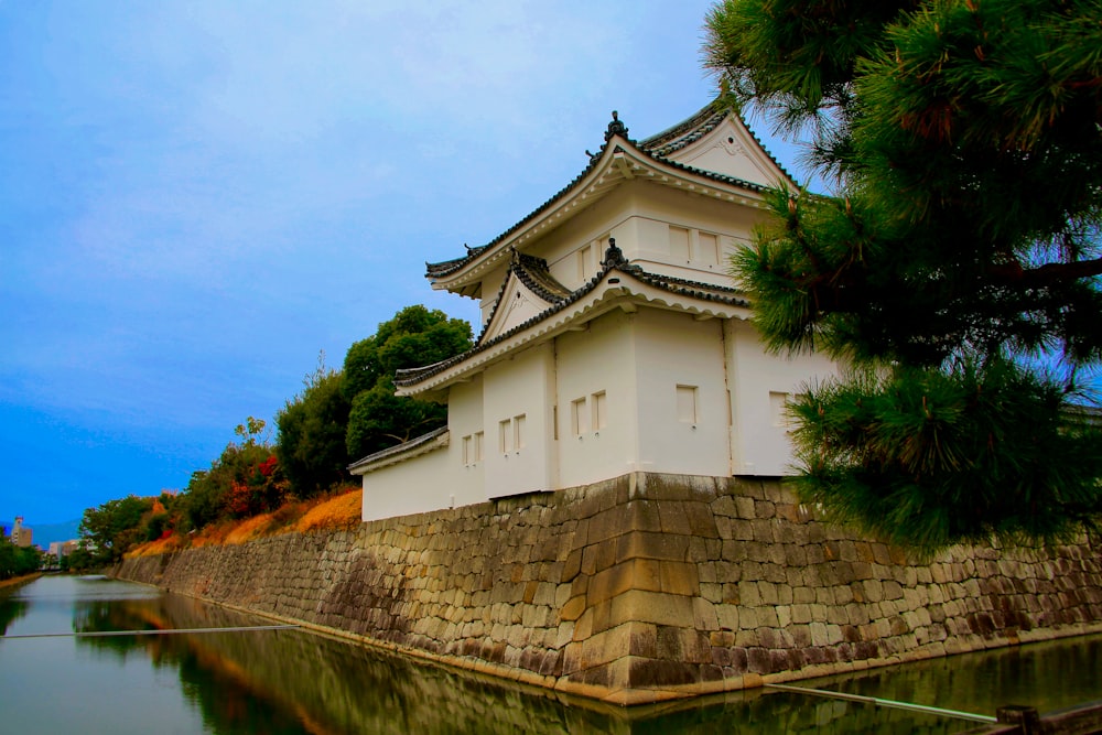 a white building sitting on top of a hill next to a body of water