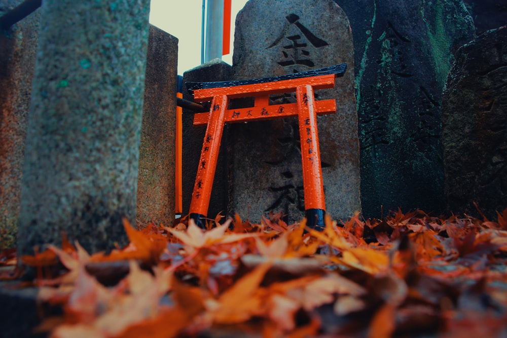 an orange chair sitting on top of a pile of leaves