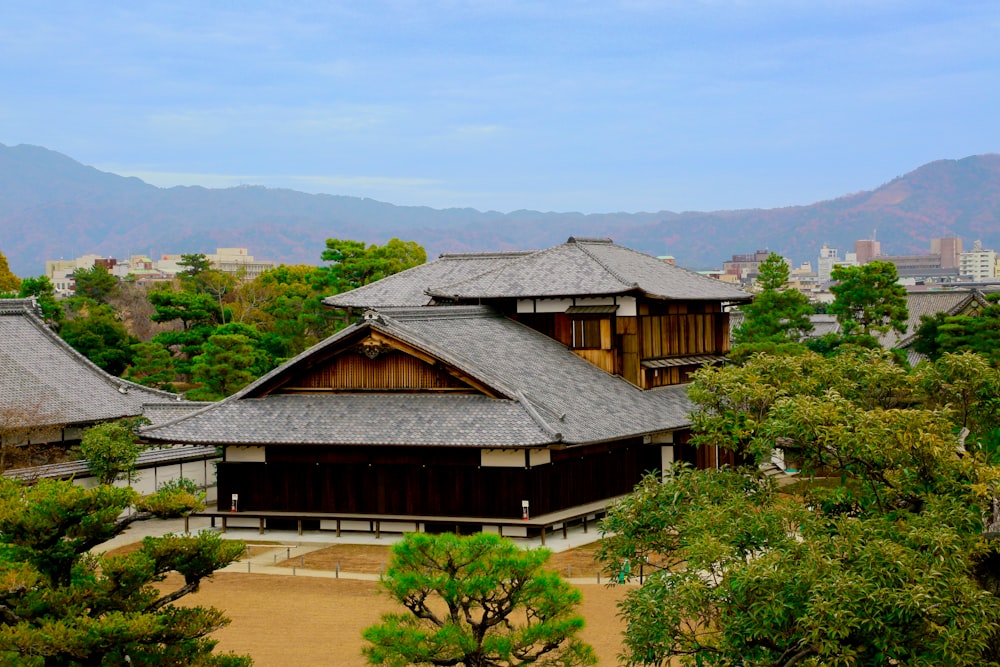 a view of a building surrounded by trees with mountains in the background