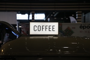 a close up of a coffee sign on a car