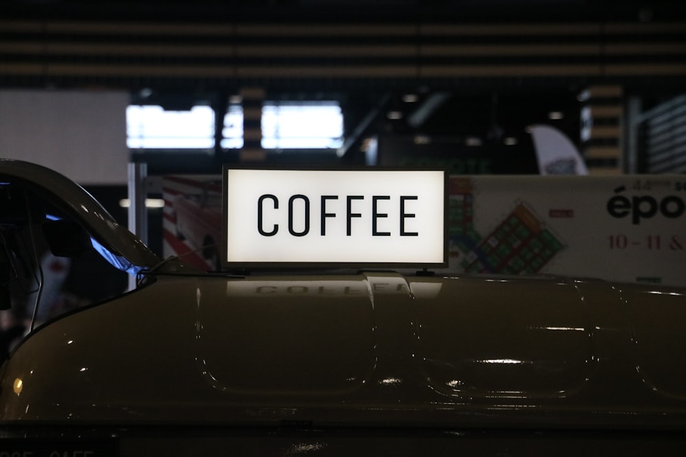 a close up of a coffee sign on a car