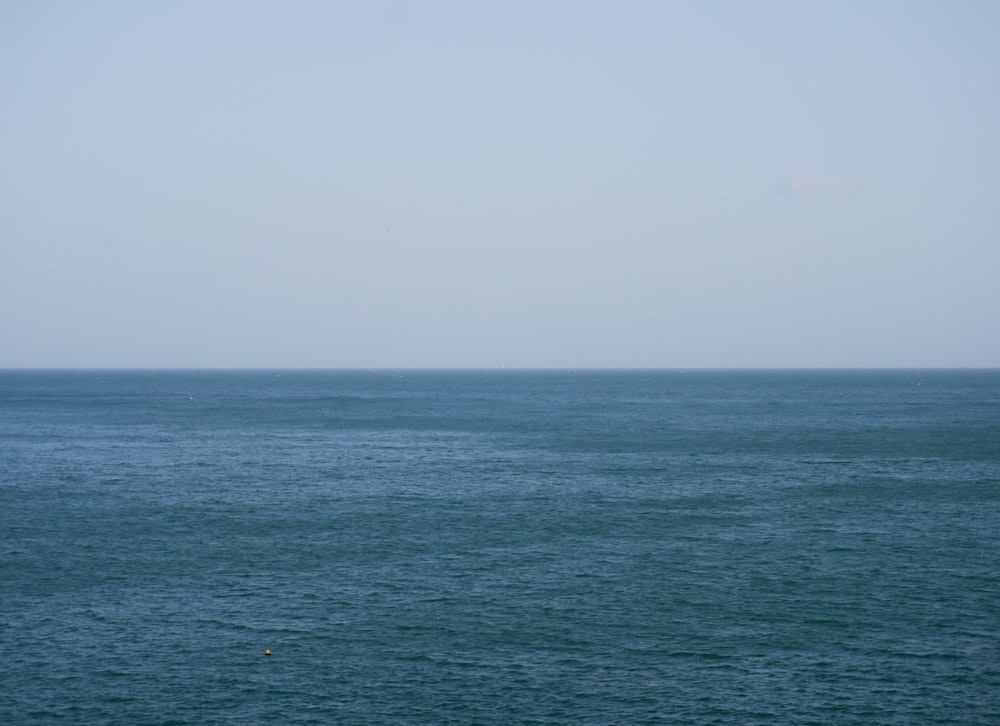 a large body of water sitting under a blue sky