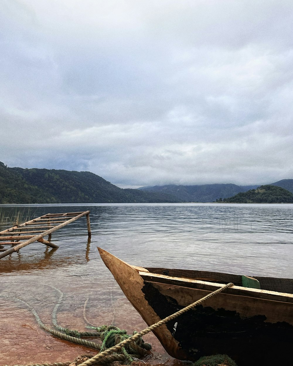 a boat sitting on top of a lake next to a dock