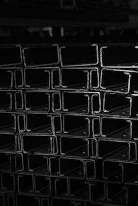 A vintage photo of iron sheets stacked neatly, symbolizing the origins of KenichiGroup.