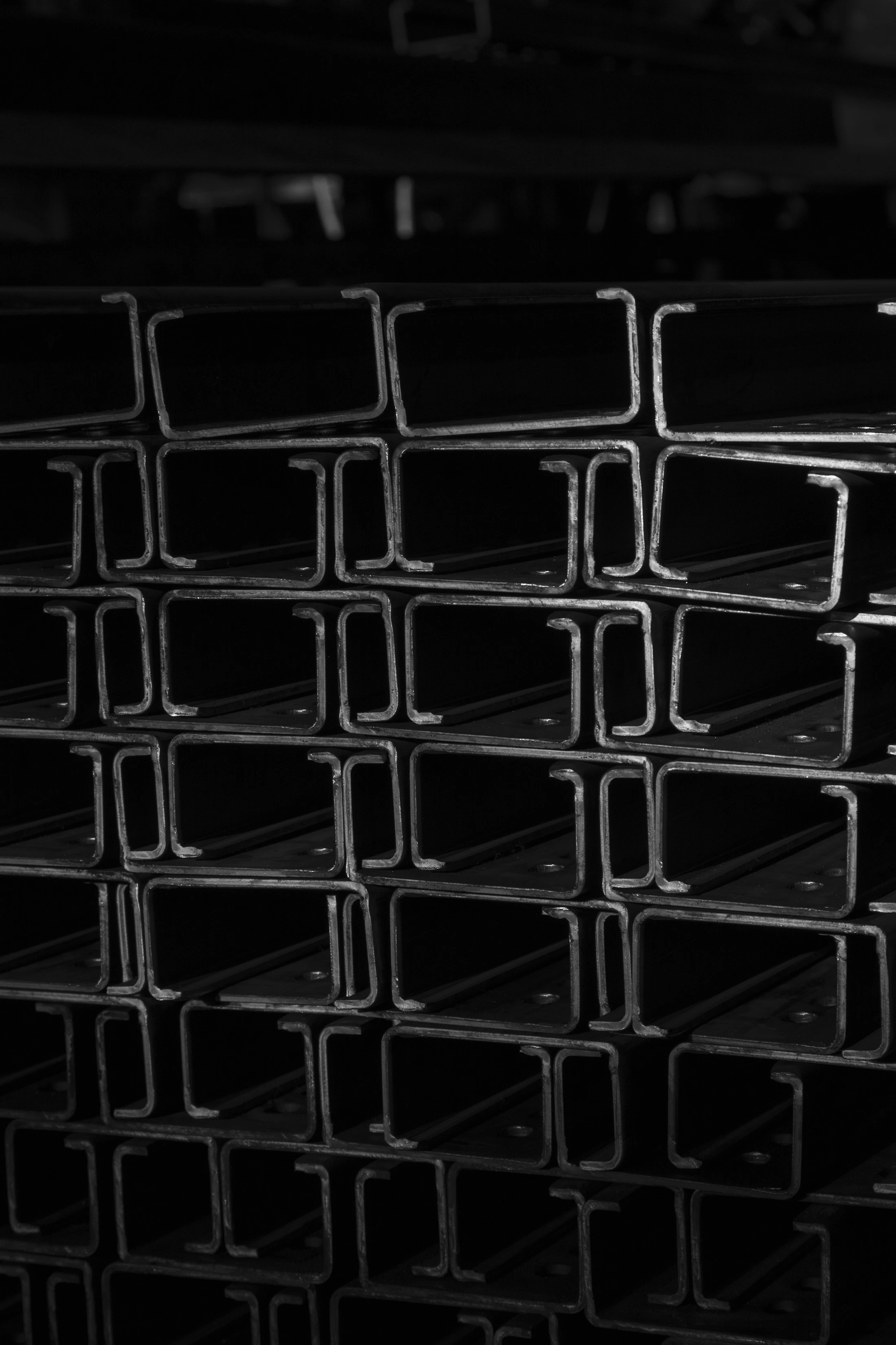 Stacked solid steel bars showing square and rectangular metal cross-sections