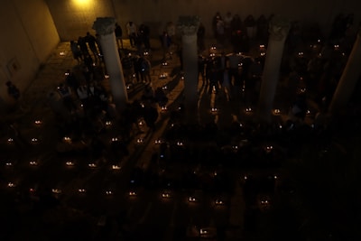 A group of people lighting memorial candles in a peaceful outdoor environment.