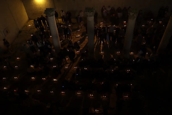 A peaceful candlelight vigil held in the church garden under a twilight sky.