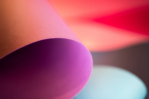 An artistic shot of hands arranging collage pieces under soft, glowing light.