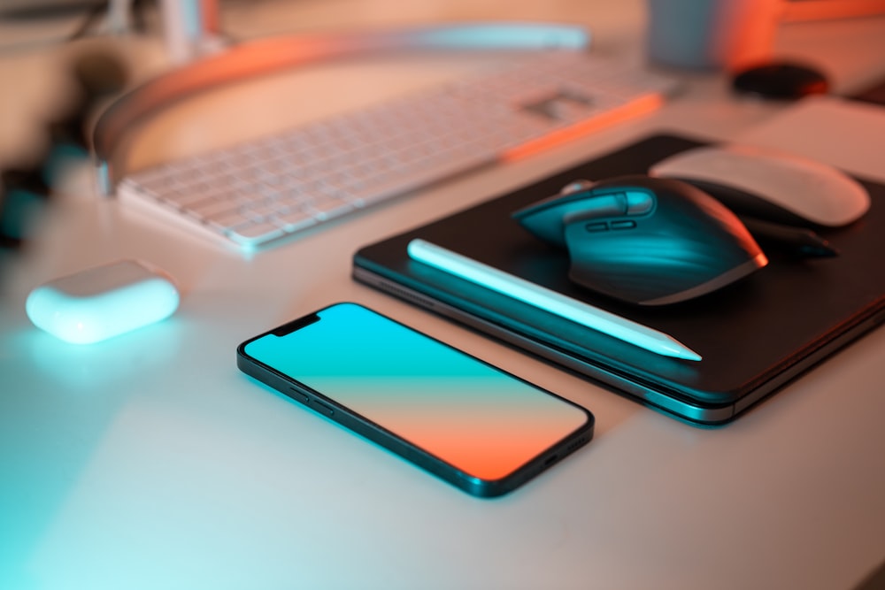 un computer portatile, un mouse e un telefono cellulare su una scrivania