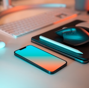 a laptop, mouse, and cell phone on a desk